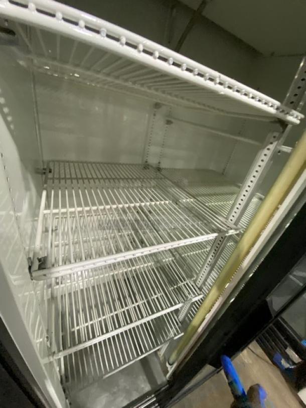 True GDM-33 commercial fridge, black double glass sliding doors, poly coated wire racks, excellent condition, 115V 1 Phase.