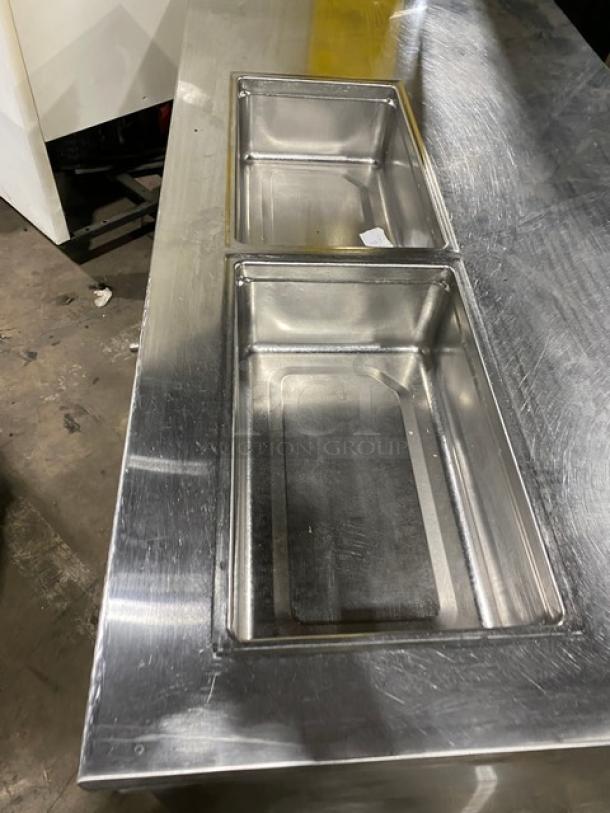 Custom stainless steel single-door refrigerated prep table with dual pans and storage shelves, on casters, in good condition.