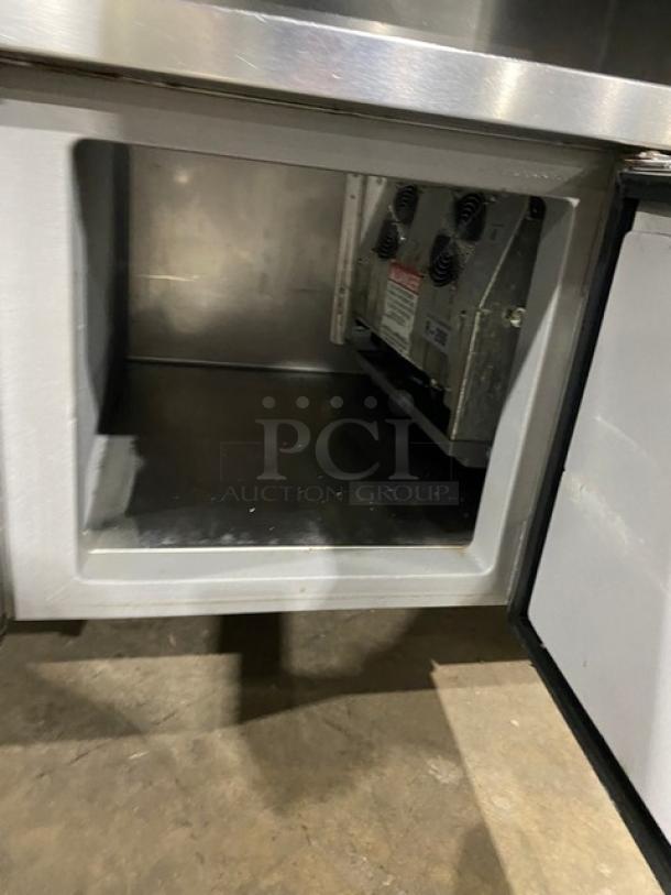 Custom stainless steel refrigerated salad/sandwich prep table with single door, enclosed storage shelves, and casters.