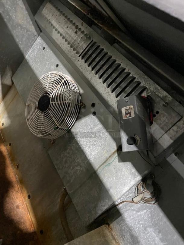 Fogel BC50DBST commercial back bar cooler interior, showing cooling fan and components. Some wear visible. Model: BC-50DBST.