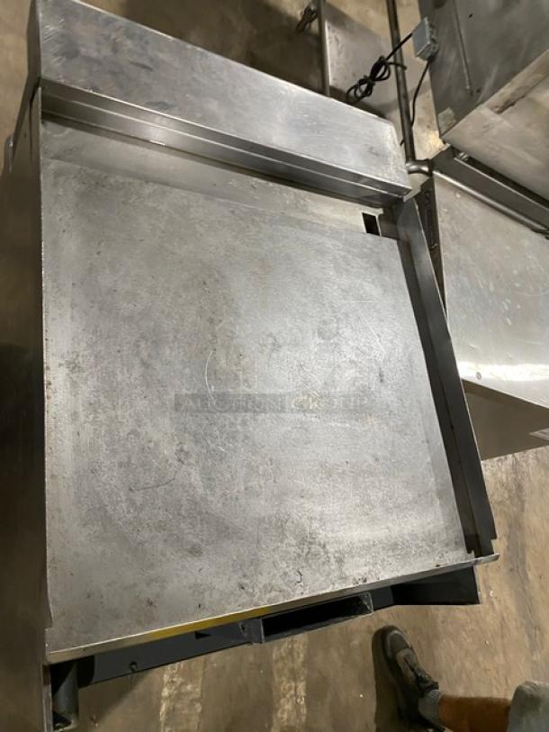 American Range commercial stainless steel flat top range/oven combo on casters. Features natural gas power and wired oven rack; used condition.
