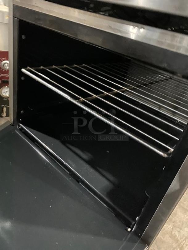 American Range commercial stainless steel flat top range/oven combo with wired oven rack, on casters, in good condition.