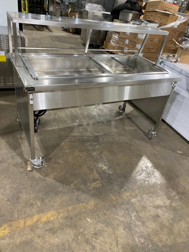 Atlas Metal WH-4 stainless steel 4-well hot food steam table with sneeze guard; electric-powered, 1 phase, on casters.