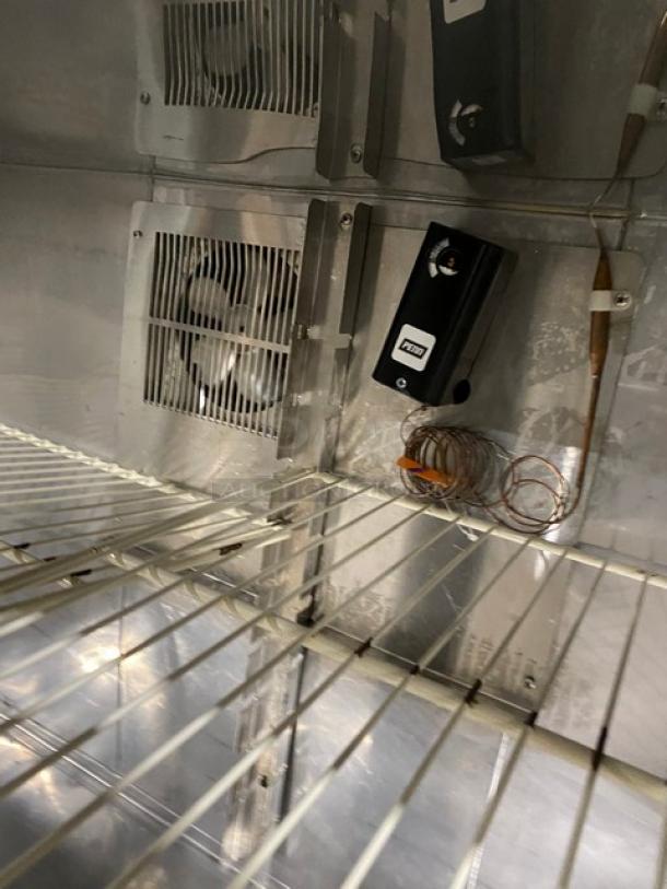 Duke RUF-48M stainless steel refrigerated worktop with poly-coated wire racks. Interior view showing fan and coil setup.