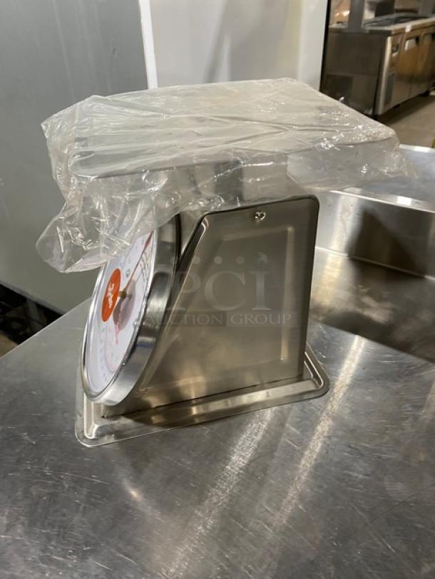 Brand new Update International UPS-840 stainless steel 40 lb. countertop scale with 8" analog dial, plastic cover intact.