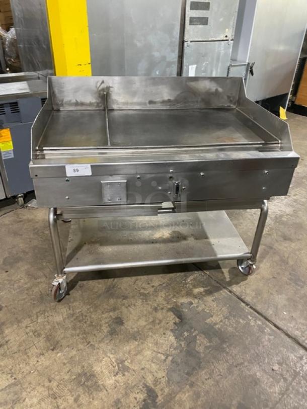 WoodStone stainless steel natural gas plancha griddle with back and side splash, single undershelf equipment cart on casters.