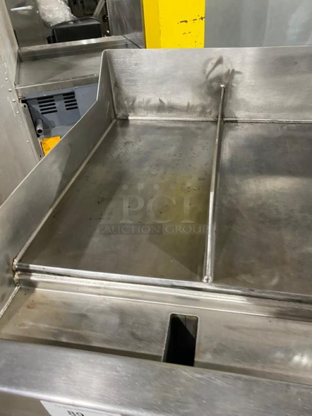 WoodStone stainless steel natural gas countertop plancha griddle with back and side splash, on undershelf cart with casters.