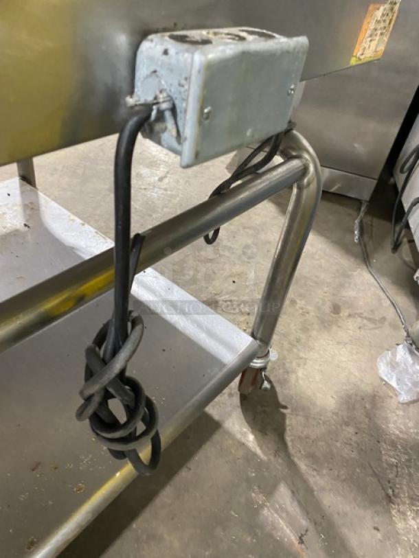WoodStone stainless steel natural gas countertop plancha griddle with back and side splash. Features single undershelf cart on casters.