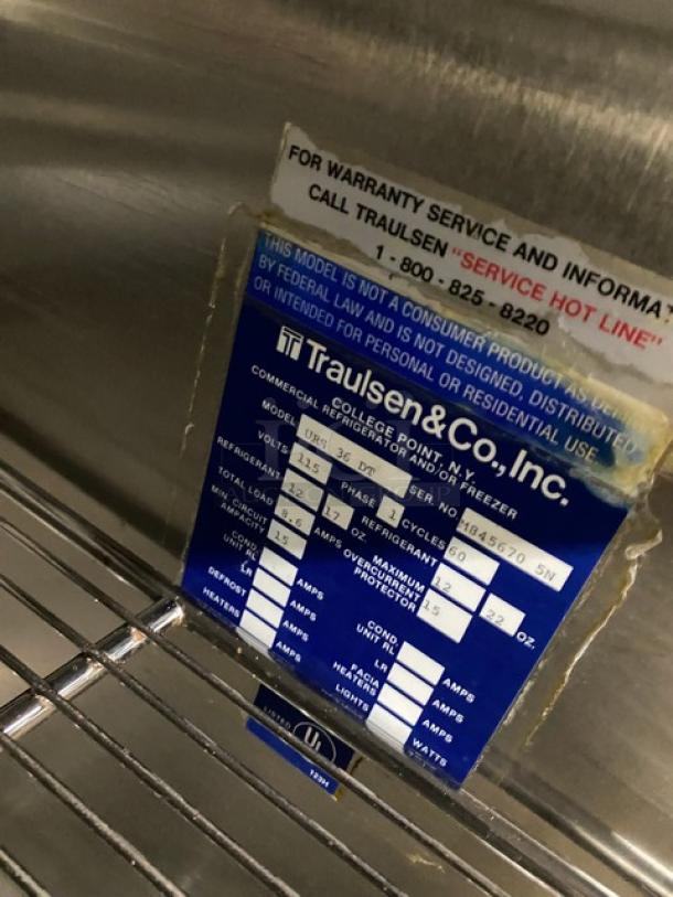 Traulsen URS36DT commercial fridge/freezer tag, with model, voltage, serial number details. Chrome wire rack below.
