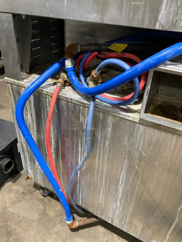 Rational SCC62G commercial combi oven, stainless steel, natural gas, double-stacked, with blue gas connector hose visible.