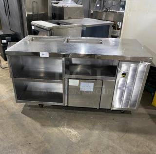 Stainless steel single door refrigerated prep table with enclosed storage shelves, on casters. Ideal for commercial use.