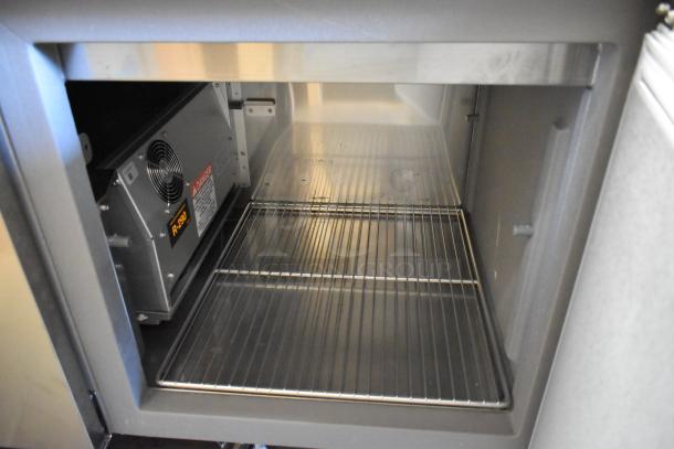 Delfield stainless steel commercial prep table interior, showing wire shelves and ventilation. Features 115 volts, 1 phase power.