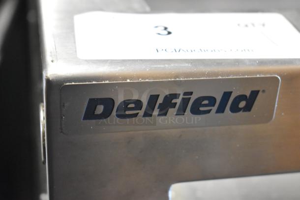 Delfield stainless steel commercial prep table with logo; features commercial casters, 115 volts, 1 phase.
