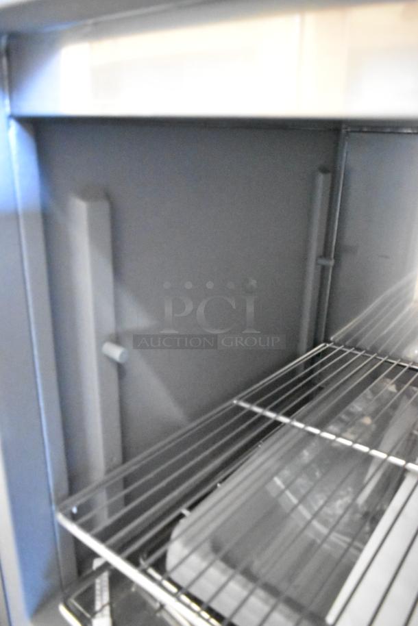 Delfield stainless steel commercial prep table interior, showing wire shelf. Suitable for 115V, 1 phase. Clean and well-maintained.