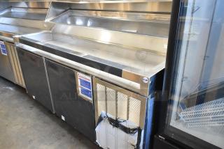 Delfield stainless steel commercial prep table, 115V, 1 phase, on commercial casters. Clean surface, minimal wear.