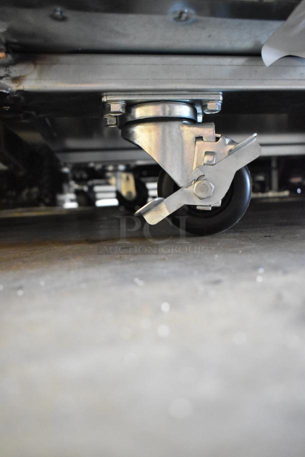 Delfield stainless steel prep table with commercial casters, 115 volts, 1 phase. Caster detail shown.