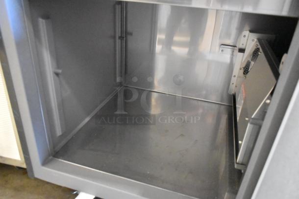 Delfield stainless steel commercial prep table interior, showing electrical components and smooth surfaces; 115 volts, 1 phase.