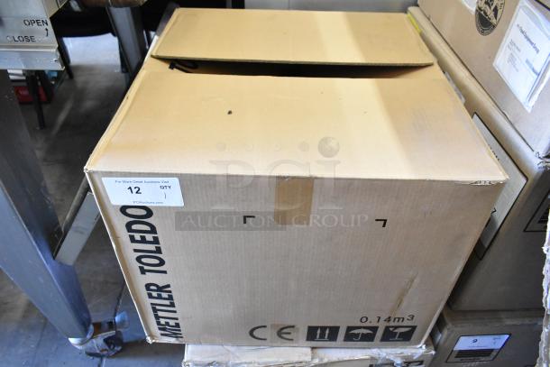 Mettler Toledo UCCW commercial scale in box, ready for auction. Features 100-240V, 1 phase. Box shows brand markings.