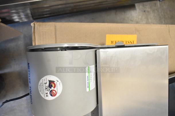 Mettler Toledo UCCW commercial countertop food scale, metal finish, 100-240V, 1 phase, label with model info visible.