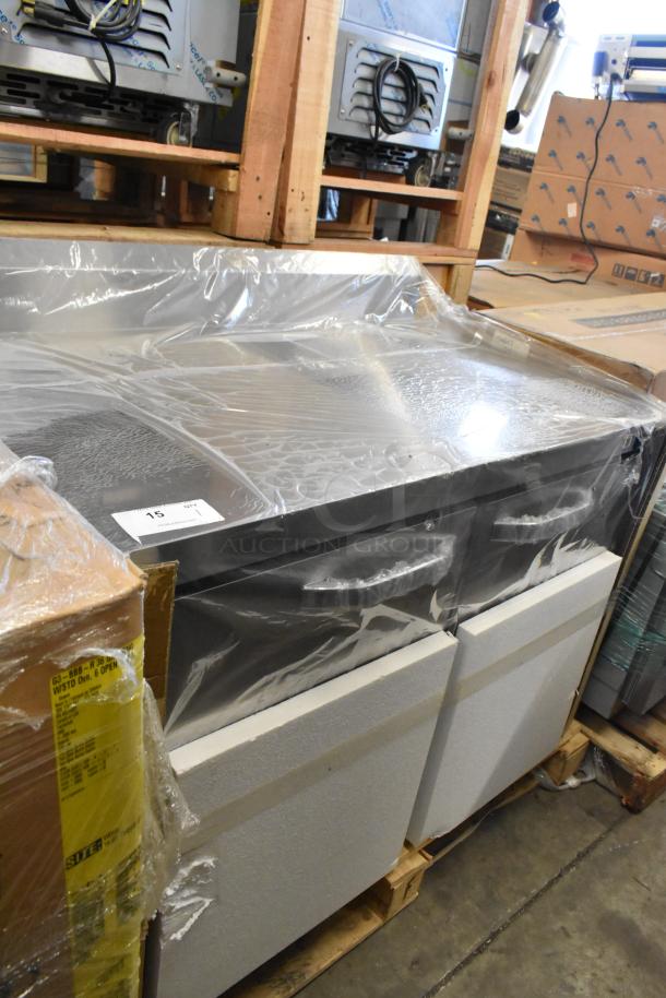 Brand new stainless steel commercial 2-door work top cooler in original packaging, minor scratches and dents visible.