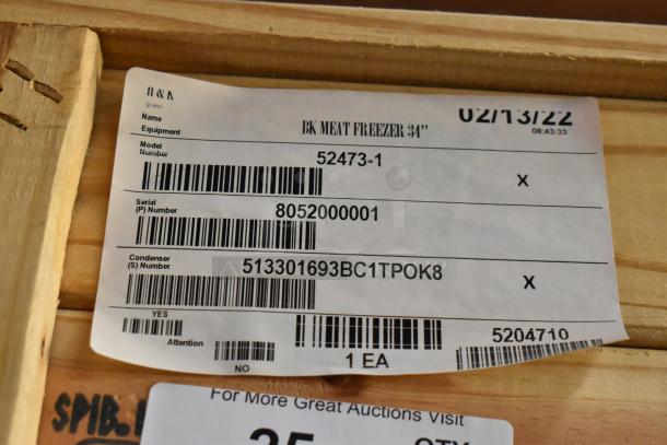 Brand new BKI 52473-1 stainless steel commercial meat freezer, in crate, on casters. 115 volts, 1 phase. Labels show model and serial numbers.