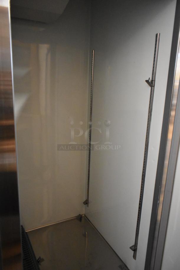 Brand new Avantco 178A49RHC stainless steel 2-door reach-in cooler interior, showing poly-coated racks and commercial casters.