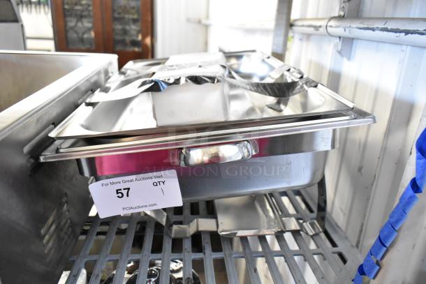 Brand new stainless steel chafer with minor scratches and dents, shown on a shelf. Features sturdy handles and standard lid.