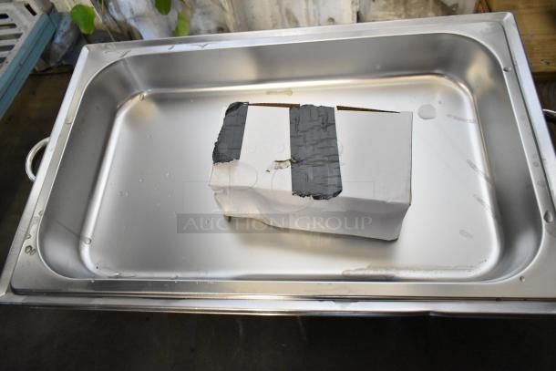 Brand new stainless steel chafer with minor scratches, featuring handles. Includes a box with tape, indicating shipping wear.