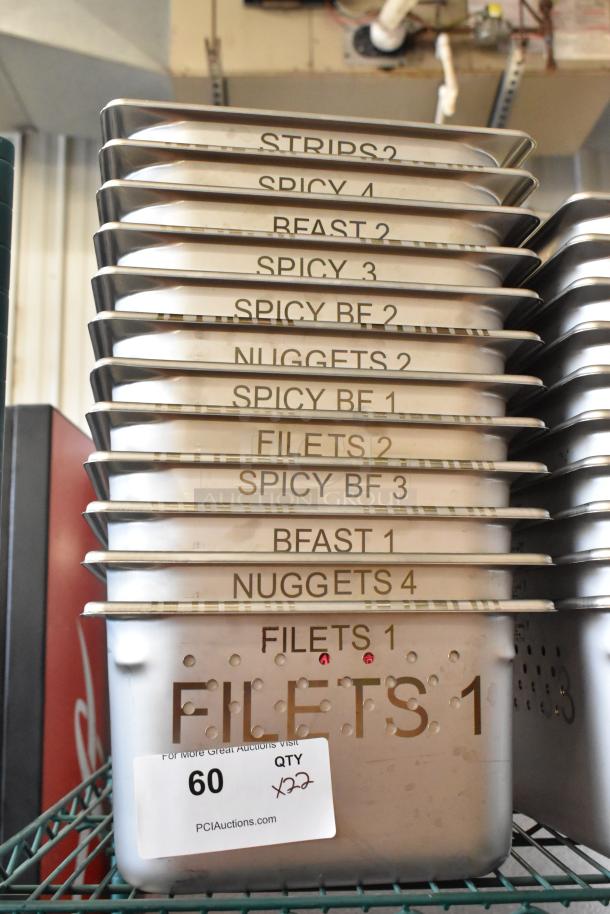 Stainless steel bins, labeled for food types, stacked on a rack. New condition, scratch and dent. Quantity: 22.
