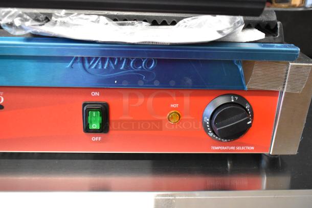 Brand new Avantco 177PG200GS panini grill, stainless steel with grooved top plate. On/off switch, temperature dial shown.