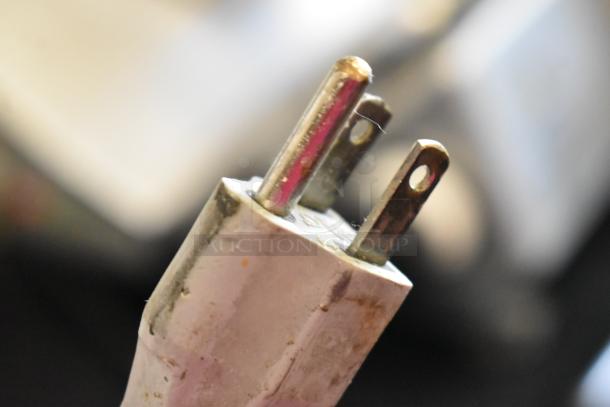 Alt text: Close-up of a three-prong plug for a 2016 Bizerba GSP HD meat slicer, showcasing details and slight wear.