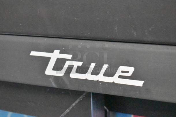 True GDM-41SL-54-HC-LD logo on black metal surface of commercial cooler merchandiser, showcasing brand branding.