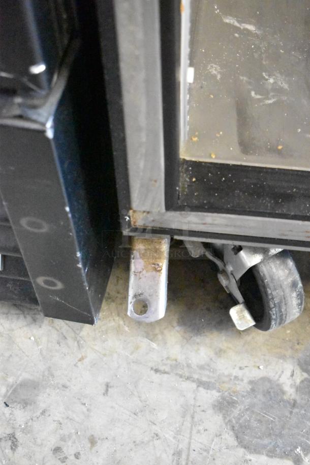 2017 True TPP-67 stainless steel pizza prep table's commercial caster close-up. Signs of wear visible. 115V, 1 phase.