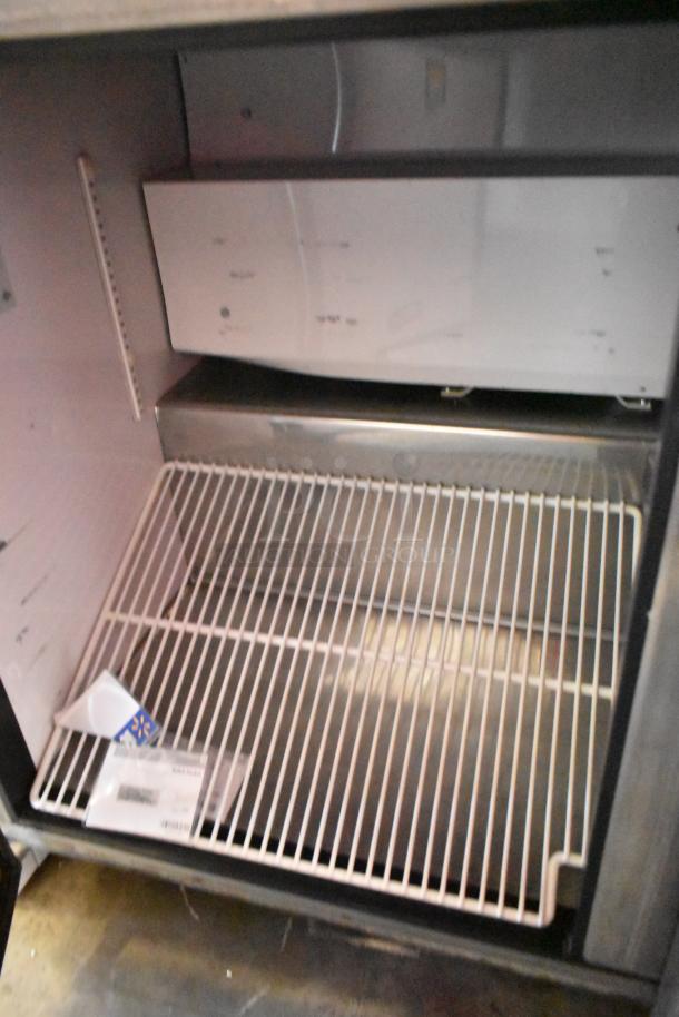 True TWT-72 stainless steel commercial pizza prep table interior with wire shelving. Features commercial casters. 115 volts, 1 phase.