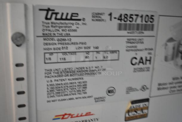 True GDM-12 commercial cooler label, shows model info, 115 volts, 1 phase, poly coated racks, serial number visible.