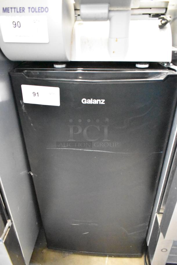 Galanz GLR33MBKE23 Metal Mini Cooler, black, 115V, 1 Phase, showing minor scratches, label "91" on door.