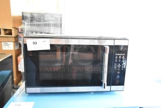 2023 Hamilton Beach HB61B100027880 metal countertop microwave with digital controls, stainless finish. Model shown with auction tag.
