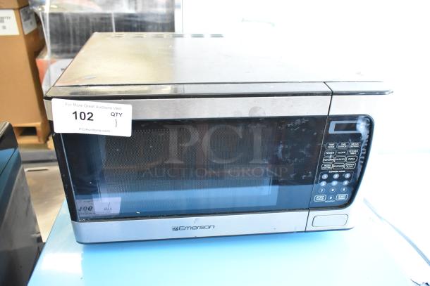Emerson MW9339SB metal countertop microwave with control panel and glass door. Auction tag "102 QTY 1" attached.