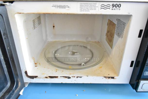 Emerson MW9339SB metal countertop microwave oven, 900 watts, with glass plate. Visible wear and interior residue.