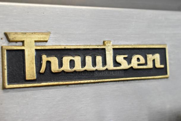 "Traulsen" badge on a stainless steel surface of a commercial heated holding cabinet and cooler. Model RDH232WUT-HHG.