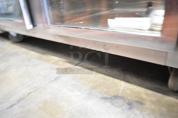 Traulsen RDH232WUT-HHG stainless steel heated holding cabinet, 2-section, 4 half-size doors, on commercial casters.