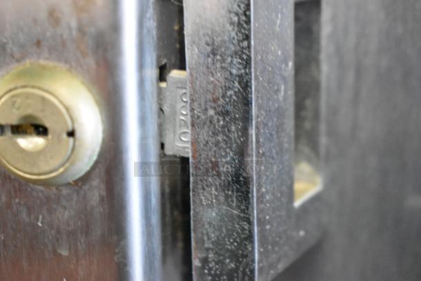 Close-up of lock on Traulsen model RDH232WUT-HHG stainless steel heated holding cabinet. Doors are locked.