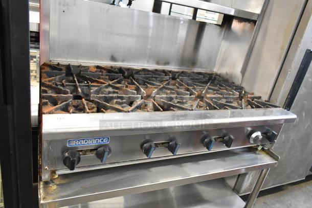 Radiance stainless steel commercial gas range, 6 burners, equipment stand, back splash, under and over shelves, casters.