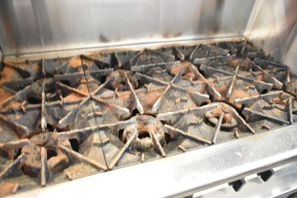 Radiance stainless steel 6-burner commercial range with backsplash, under and over shelves, on casters. Used condition.