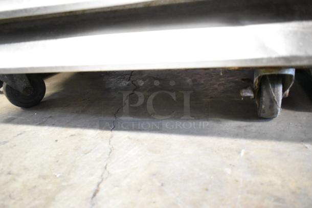 Avantco 178A19RHC cooler with commercial casters, visible from the bottom showing two wheels on concrete floor.