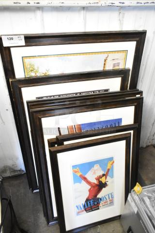 12 various framed pictures, including chefs, stacked. Good condition, black frames, and diverse artwork styles. Auction tag visible.