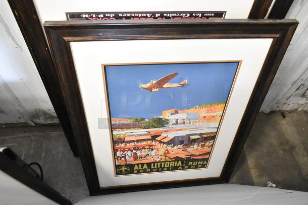 Framed vintage travel poster depicting an airplane over a marketplace, labeled "Ala Littoria S. Roma Servizi Aerei."