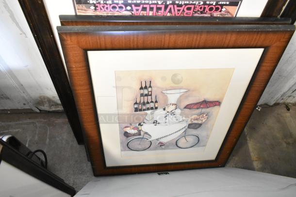 Framed picture featuring a whimsical chef on a bicycle, balancing wine bottles and baguettes. Brown wood frame, excellent condition.