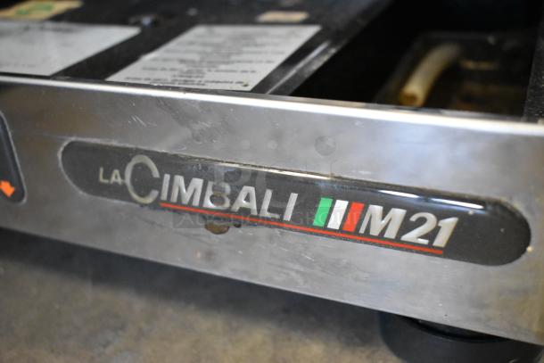La Cimbali M21 Junior NF espresso machine, stainless steel, visible brand logo, includes portafilter and steam wand.