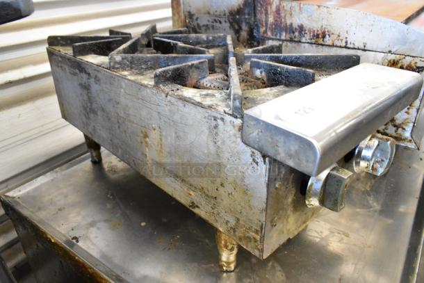 Stainless steel commercial countertop 2 burner gas range. Shows signs of wear and use. Knobs intact, sturdy build.